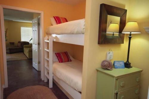 a bedroom with two bunk beds and a room with a mirror at Grand Beach Resort Unit 106 in Gulf Shores