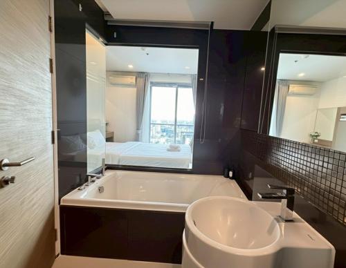 a bathroom with a tub and a sink and a mirror at The Onnut Nest 1BR Sofa Bed Onnut BTS 50m in Bangkok