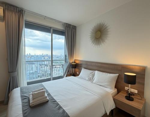 a bedroom with a large bed and a large window at The Onnut Nest 1BR Sofa Bed Onnut BTS 50m in Bangkok