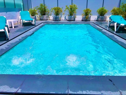 a swimming pool with blue chairs at Janota Week with pool in Setúbal