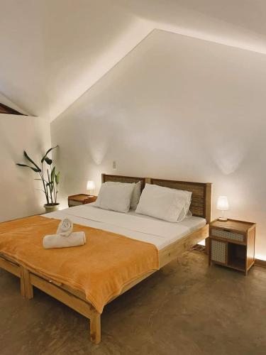 a bedroom with a large bed and two night stands at Meraki Siargao Resort in General Luna