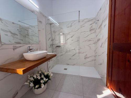 bagno bianco con lavandino e pareti in marmo di Ca Ses Celleres a La Mola