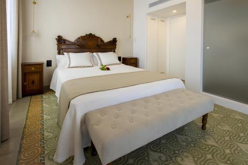 - une chambre avec un grand lit blanc et un banc dans l'établissement Habitación Rossinyol, à Castellví de la Marca