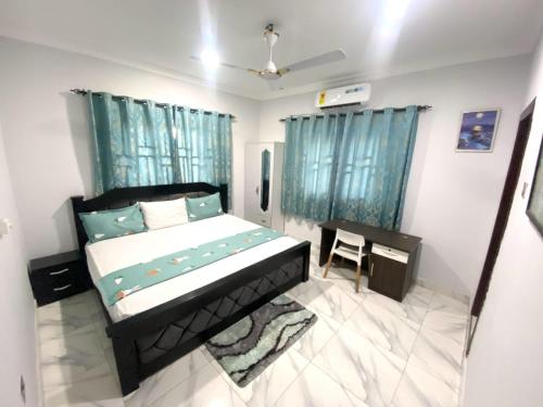 ein Schlafzimmer mit einem Bett und einem Schreibtisch in der Unterkunft Happy Home in Weija