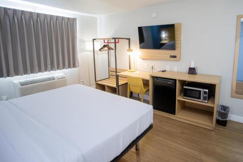a hotel room with a bed and a desk with a microwave at Park Inn by Radisson in Fargo