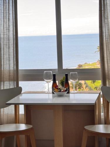 a table with two wine glasses and a bowl of fruit at The View Calahonda Primera Línea de Playa y Vistas Panorámicas in Mijas Costa