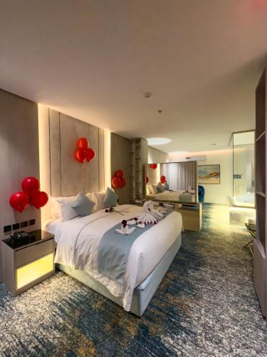 a bedroom with a large bed with red balloons on it at Rose Garden Hotel فندق روز جاردن in Riyadh