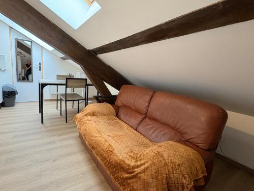 een leren bank in een woonkamer met een tafel bij Studios 4 nations in Épinal