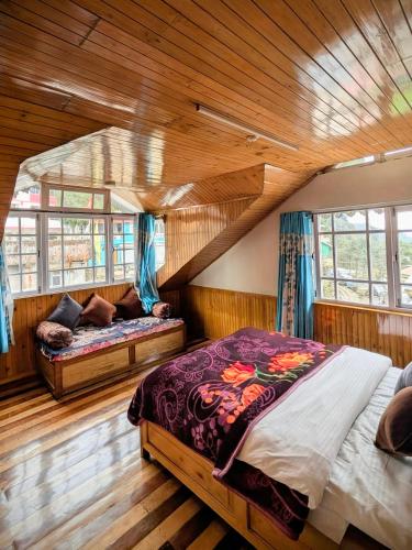 a bedroom with a bed and a couch in a room at Foggy Hill's Darjeeling in Darjeeling