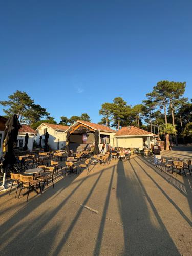 een groep tafels en stoelen op straat bij Chez "Greg et ilhem" in Lège-Cap-Ferret