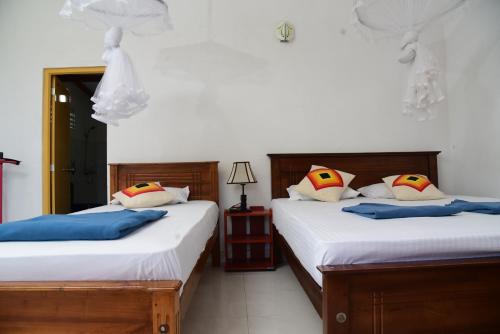 a bedroom with two beds and a night stand at Super View Home Stay in Ella