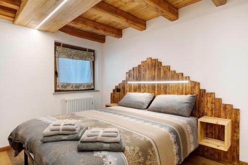 a bedroom with a large bed with a wooden headboard at La Maison du Brenand in Rhêmes-Notre-Dame