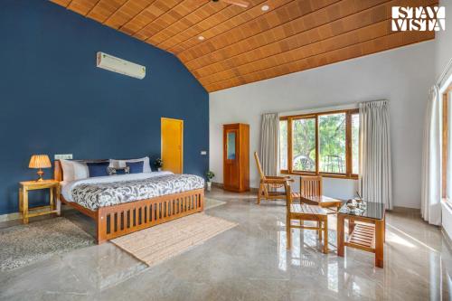 een slaapkamer met een bed, een tafel en stoelen bij StayVista at Jims Farmstay with Pool, Pet-friendly in Halgūr