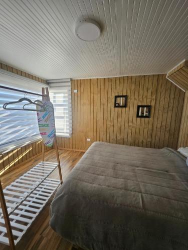 a bedroom with a large bed with a wooden ceiling at Loft playaBlanca in Coronel