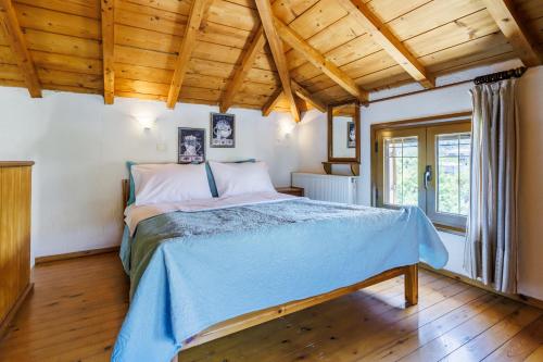 a bedroom with a bed in a room with wooden ceilings at Studios Galini in Skopelos Town