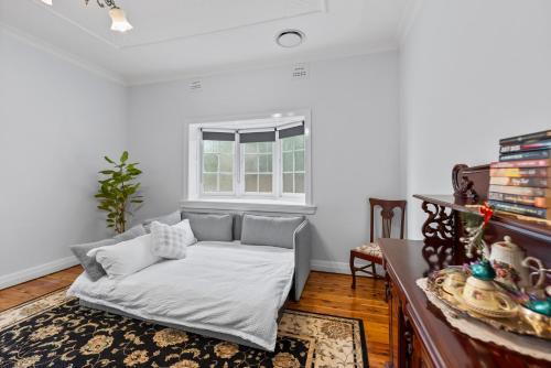 a white living room with a couch and a window at Cottage on Carthage in Tamworth