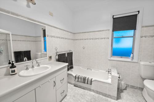 a bathroom with a sink and a tub and a toilet at Cottage on Carthage in Tamworth