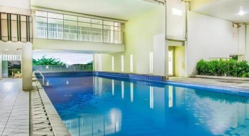 ein großes Schwimmbecken mit blauem Wasser in einem Gebäude in der Unterkunft Bogor Valley Hotel in Kalibata 1