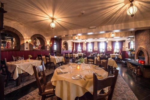 a restaurant with tables and chairs in a room at Hotel Restaurant in den Hoof in Maastricht