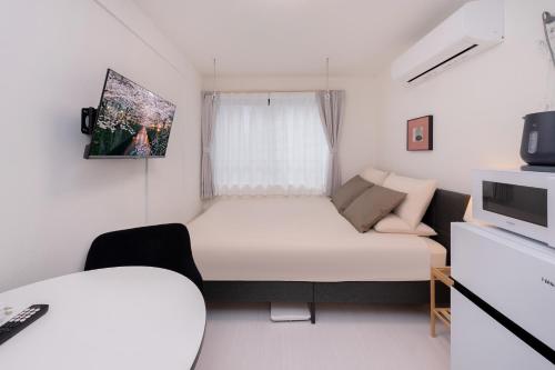 a small room with a bed and a couch at Crecer Apartment Hotel kamata in Tokyo