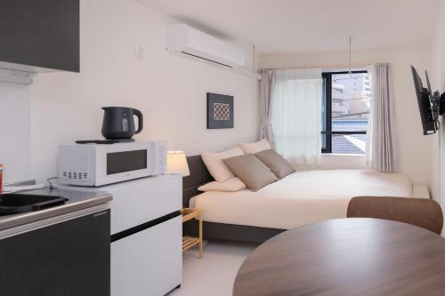 a small living room with a couch and a microwave at Crecer Apartment Hotel kamata in Tokyo