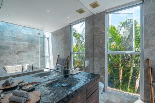 a bathroom with a large sink and a large window at Villa Ashoka Canggu in Canggu