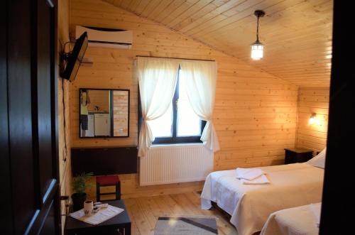 a bedroom with two beds and a window in a room at Complex Agroturistic Livada de Nuci in Baia de Fier