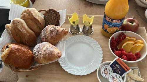 een tafel met een bord gebak en een fruitschaal bij Homestorys Nature Resort in Eupen