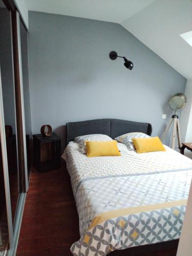 una camera da letto con un letto con due cuscini gialli di Chambres d'hôte d'Amboise a Amboise