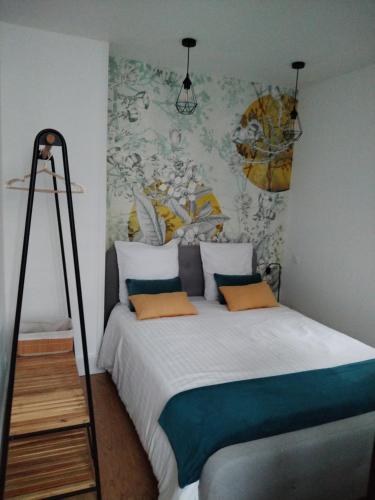 una camera da letto con un letto grande con un dipinto sul muro di Chambres d'hôte d'Amboise a Amboise