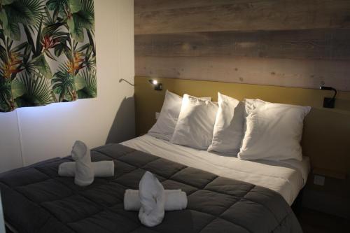 une chambre d'hôtel avec un grand lit avec deux oreillers dans l'établissement Studiotel premium 2 personnes, à Pamiers