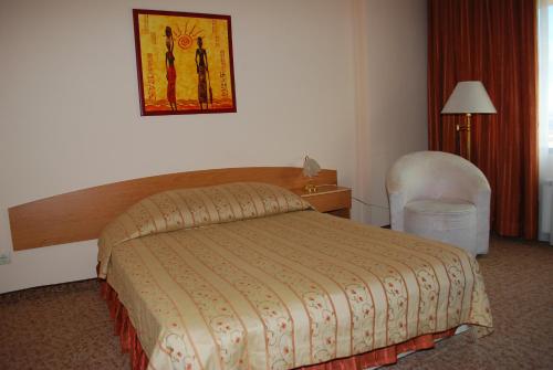 a hotel room with a bed and a chair at Hotel Velbazhd in Kyustendil
