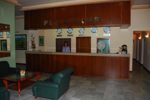 a woman standing at a counter in a waiting room at Hotel Velbazhd in Kyustendil