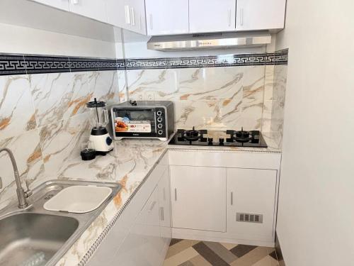 a white kitchen with a sink and a stove at Amlana villa in Gili Trawangan