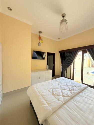 a bedroom with a large bed and a window at Amlana villa in Gili Trawangan