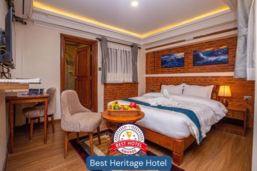 a hotel room with a bed and a table and chairs at Darbar Heritage Inn in Kathmandu