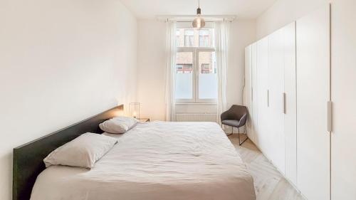 a white bedroom with a large bed and a window at Modern apartment near City Centre, Luna CasaMia in Mellet