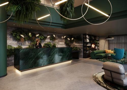 een vrouw die achter een balie in een lobby staat bij Motel One Frankfurt-Hauptbahnhof in Frankfurt am Main