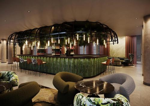 een lobby met een bar met stoelen en tafels bij Motel One Frankfurt-Hauptbahnhof in Frankfurt am Main
