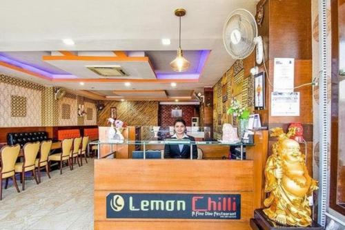 a restaurant with a woman sitting at a counter at Hotel Black Diamond, Patiala Chok 2 min from Zirakpur Bus Stand near Panchkula in Zirakpur