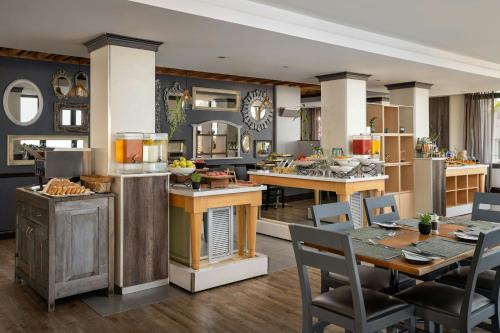 een keuken en eetkamer met een tafel en stoelen bij Protea Hotel by Marriott Cape Town Waterfront Breakwater Lodge in Kaapstad