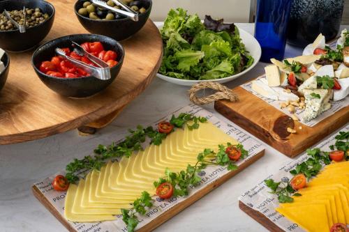 een tafel met kaas en andere voedingsmiddelen op borden bij Protea Hotel by Marriott Cape Town Waterfront Breakwater Lodge in Kaapstad