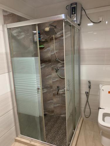 a glass shower in a bathroom with a toilet at JHome in Kurunegala
