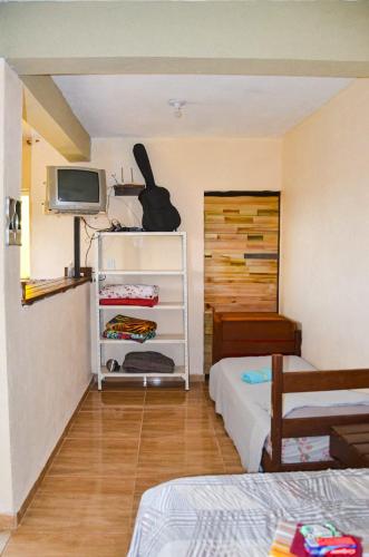a room with two beds and a television and a room at Casa clima da montanha 1 in Cunha