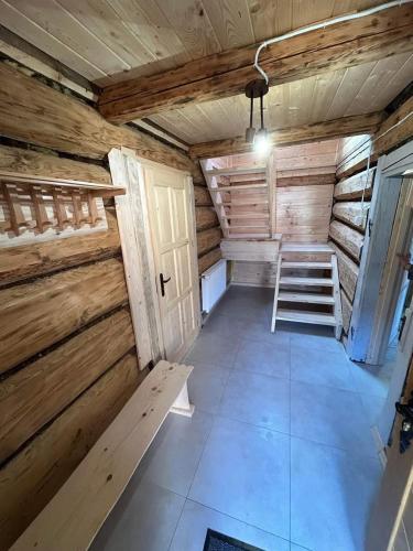een lege kamer met een ladder in een houten hut bij Dom Sidzina in Sidzina