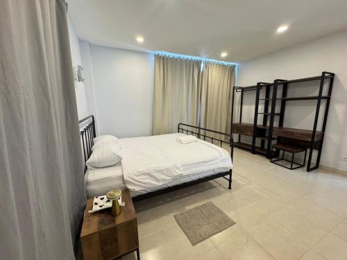 a bedroom with a bed and a table and a bench at Cozy Stay in Ban Nong Waeng