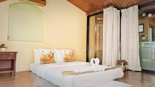 a bedroom with two beds and a window at Phangnga Cottage in Phangnga