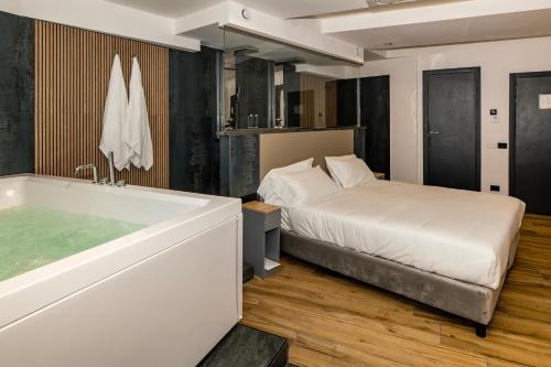 een slaapkamer met een bed en een bad bij Golden Hotel in Napels