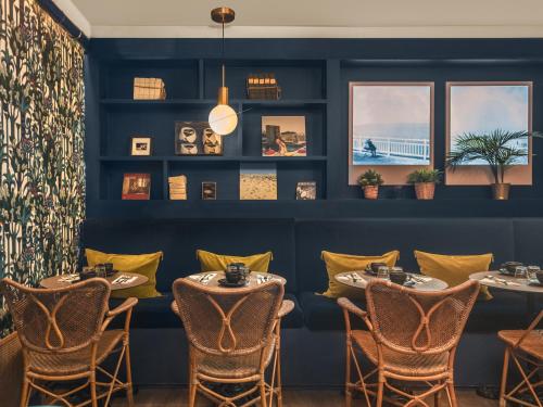 a dining room with tables and chairs and a blue wall at Handsome Hotel in Paris