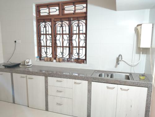 a kitchen with a sink and a window at Richnest Apartment and villas Colva in Colva